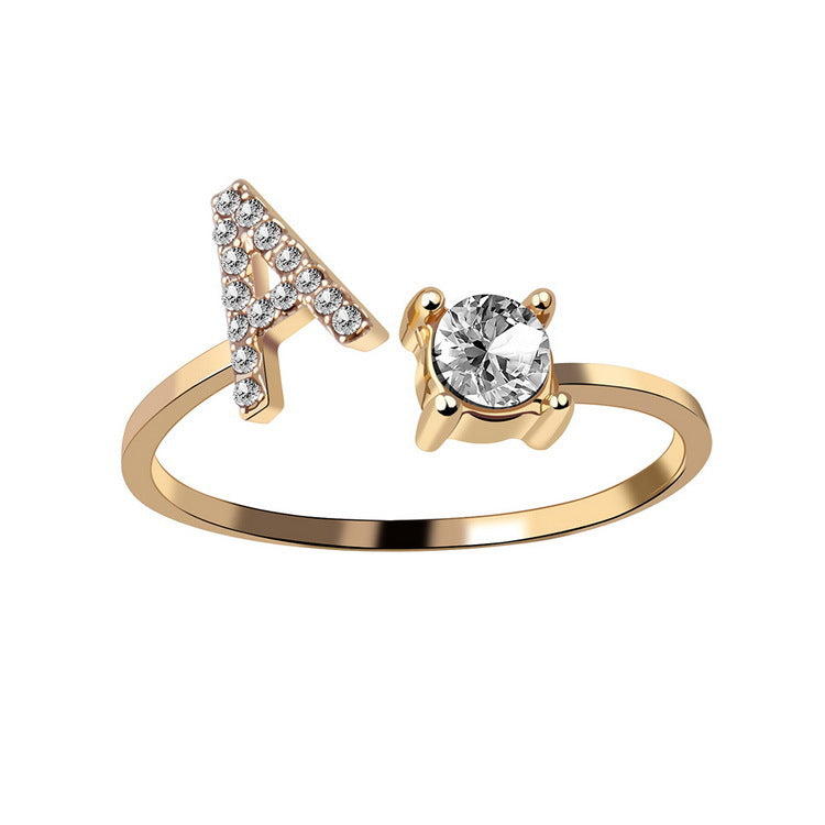 Gold ring with letter 'A' and diamond on a white background
