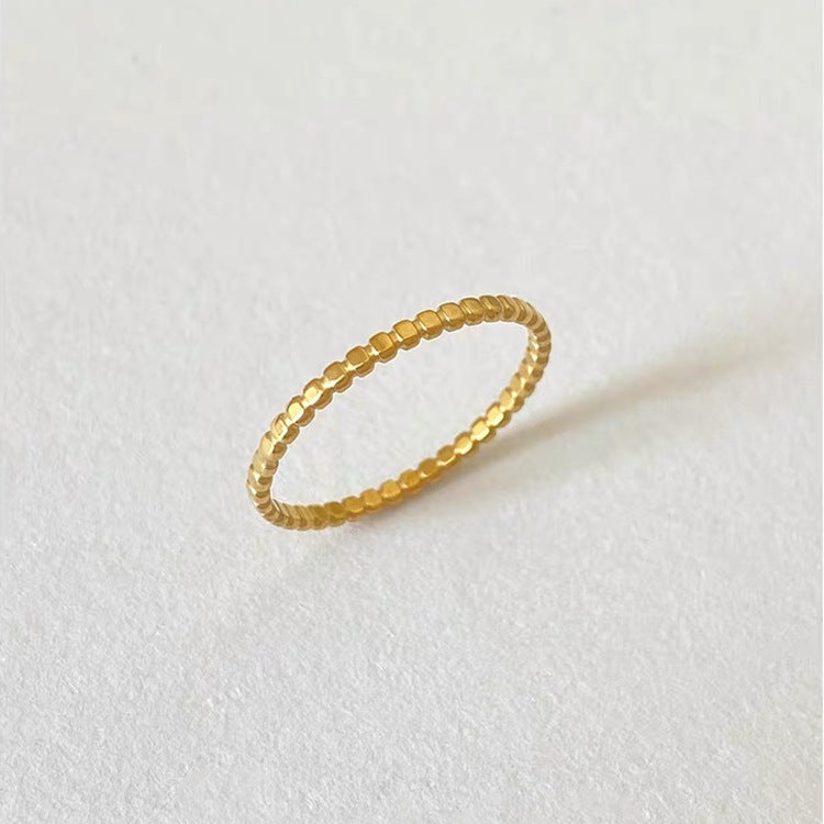 Gold ring on a light gray background