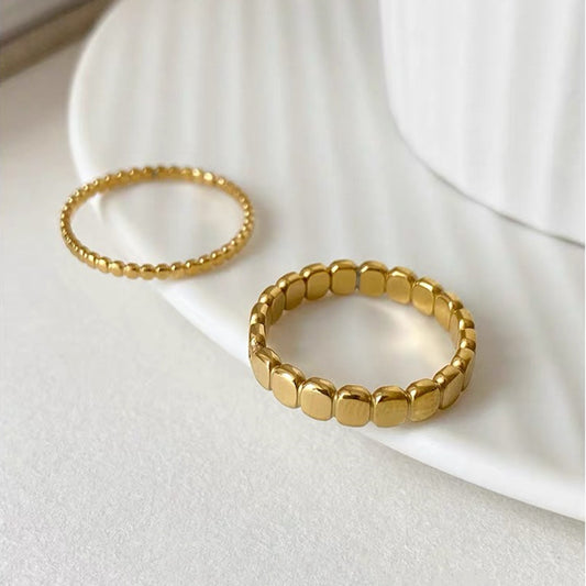 Two gold rings on a white surface